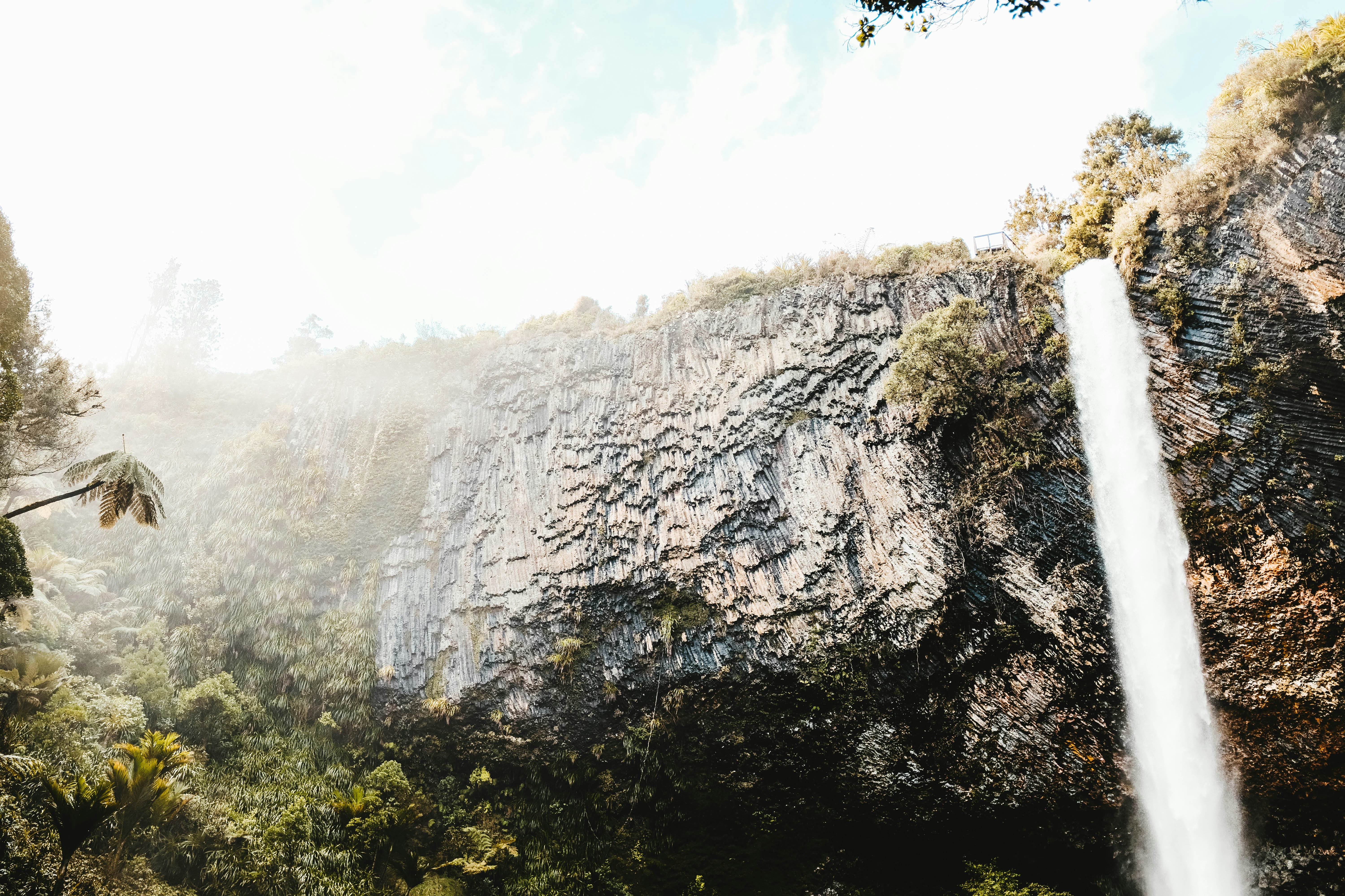 time lapse photography of falls from the cliff under white clouds